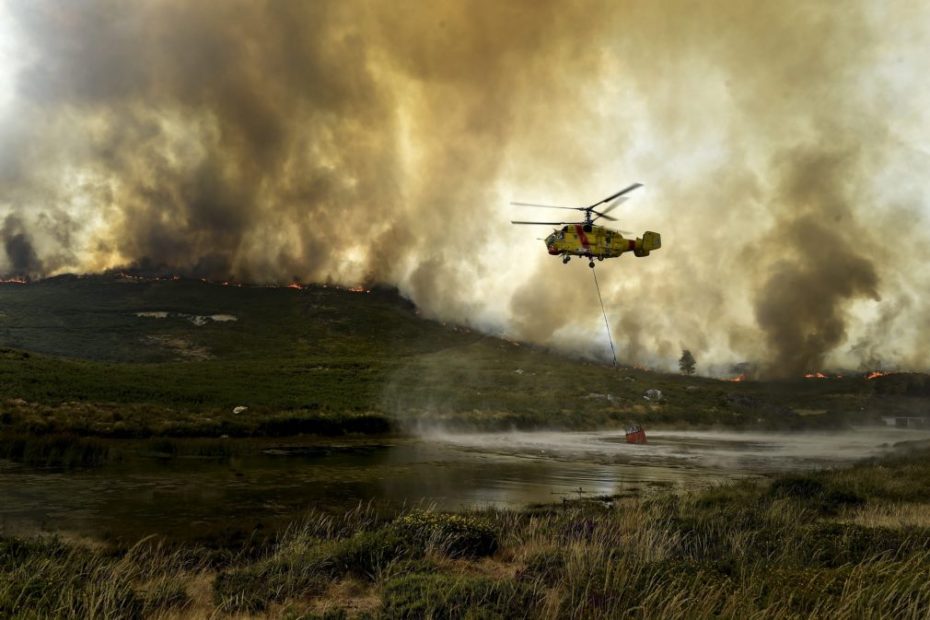 Un helicóptero Kamov toma agua de un río para ayudar a extinguir el incendio forestal en S. Pedro do Sul, distrito de Viseu, Portugal central, 14 de agosto de 2016. EPA / NUNO ANDRE FERREIRA