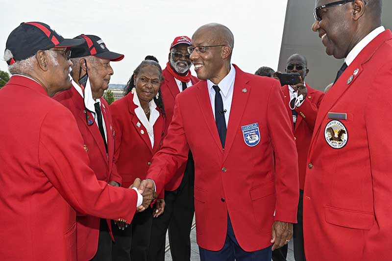 El Jefe de Estado Mayor de la Fuerza Aérea, General CQ Brown, Jr. saluda a los miembros de Tuskegee Airmen Inc. después de una ceremonia en el Air Force Memorial, Arlington, Va., el 14 de agosto de 2021. Brown recibió una chaqueta roja simbólica, lo que lo convierte en un honorario Aerotécnico de Tuskegee. (Foto de la Fuerza Aérea de EE. UU. Por Eric Dietrich)