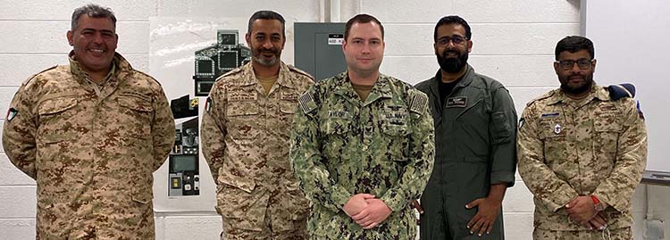 (De izquierda a derecha) Los estudiantes de la Fuerza Aérea de Kuwait Wakil'awal Fahad Almalek, Talal Albaloul, Meshal Hadi y Abdulaziz Alrashed se encuentran con su instructor del Centro de Entrenamiento Técnico de Aviación Naval de la Unidad de Oceana, el Electricista de Aviación de Primera Clase Andrew Taylor (centro). Taylor ayudó a los estudiantes kuwaitíes a adquirir conocimientos sobre las diversas actualizaciones del F/A-18E/F Super Hornet, para los Hornets heredados que la Fuerza Aérea de Kuwait había estado volando.