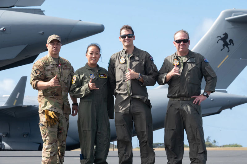Los jefes de carga de la Fuerza Aérea de los Estados Unidos del 204º Escuadrón de Transporte Aéreo, el Sgto. Josh Moracco y Sandra Kim, y los jefes de carga de la Real Fuerza Aérea Australiana del Escuadrón 87, el sargento Ben Russell y el sargento Jay Johnson, se reúnen el 12 de mayo de 2022 en la Base Conjunta Pearl Harbor-Hickam, Hawái. Los miembros de las tripulaciones aéreas de cada nación compartieron responsabilidades en las aeronaves del otro durante el ejercicio de entrenamiento Global Dexterity. Foto del Sargento John Linzmeier (ANG/USAF)