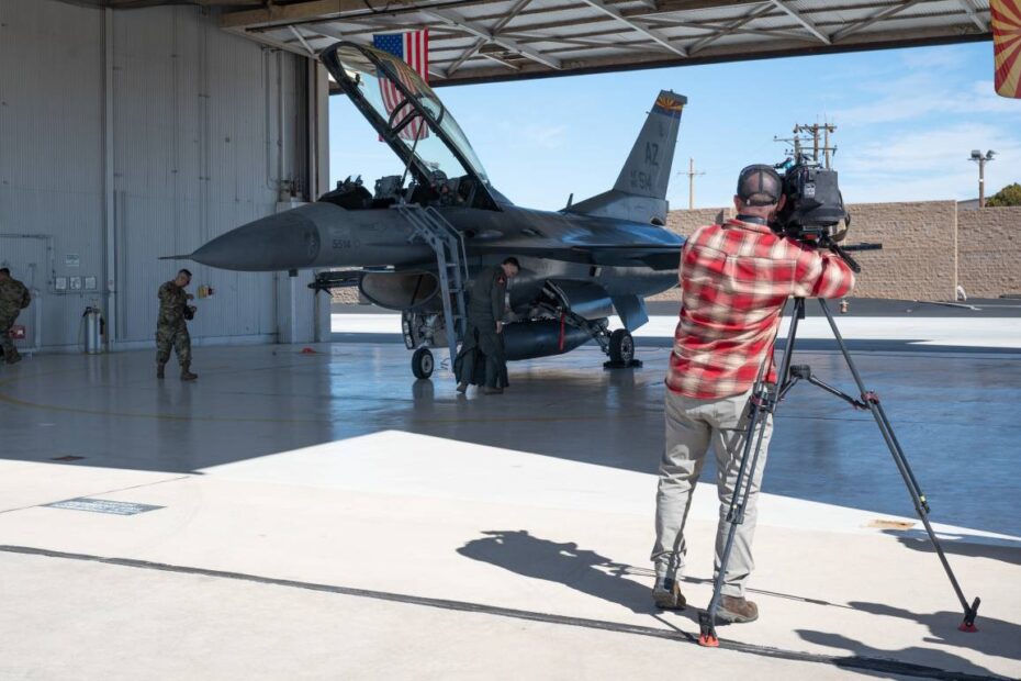 El camarógrafo de Fox News, Bryan Allman, filma al corresponsal de noticias, Matt Finn, mientras se prepara para el vuelo en un F-16 para destacar los esfuerzos de seguridad de defensa aérea que se llevarán a cabo sobre el State Farm Stadium en Glendale, Arizona, durante el Super Bowl LVII el 12 de febrero. (Foto de la Fuerza Aérea de EE.UU. por la Mayor Angela Walz)