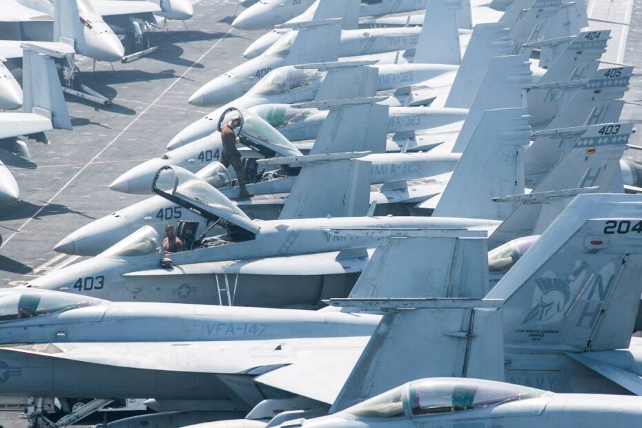 Marines estadounidenses asignados al Escuadrón de Ataque de Cazas de la Infantería de Marina (VMFA) 323 realizan tareas de mantenimiento en aviones F/A-18C Hornet en la cubierta de vuelo del portaaviones USS Nimitz (CVN 68). Fotografía de la Marina de los Estados Unidos por la especialista en comunicación de masas de segunda clase Nichelle N. Bishop