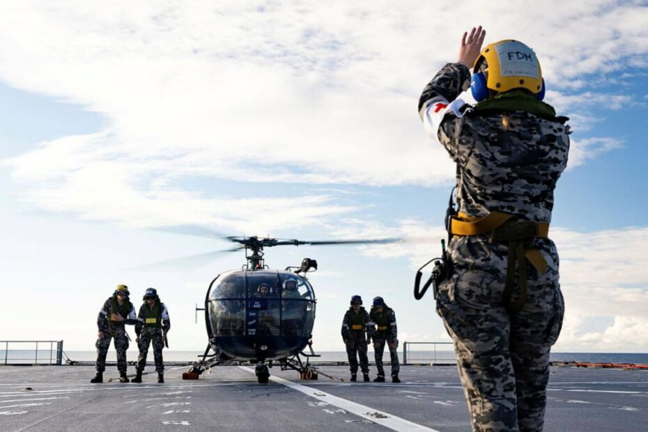 Leading Seaman Maritime Personnel Operator Kendall Warner marshalls Indian Navy Chetak helicopter onboard HMAS Choules during Exercise Malabar 2023, NSW. ©Defensa Australia