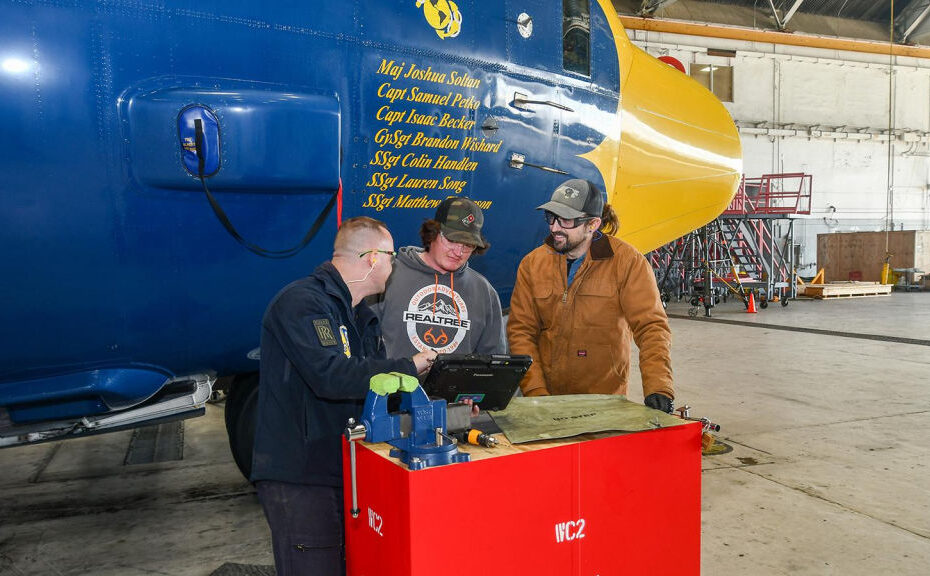 En un hangar del Fleet Readiness Center East (FRCE), el suboficial a cargo del equipo de mantenimiento Fat Albert, el sargento Patrick Angles, a la izquierda, habla sobre el trabajo programado para el C-130J conocido como Fat Albert con el mecánico de chapa metálica del FRCE Hunter Littrell, en el centro, y el ayudante de mecánico Luke Baker. El Equipo de Inspección de Depósitos Menores del FRCE ayudó al Equipo de Mantenimiento del Fat Albert a realizar el mantenimiento y las inspecciones anuales, lo que dio como resultado un tiempo de respuesta más rápido para el equipo del Fat Albert y una exposición beneficiosa para los empleados del FRCE. ©FRCE