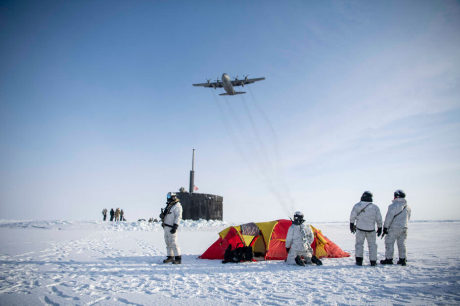 Un Hércules C-130 asignado a la 109ª Ala de Transporte Aéreo de la Guardia Nacional Aérea de Nueva York sobrevuela a Operadores Navales de Guerra Especial (SEAL) con base en la Costa Este, comandos de Operaciones Navales Especiales noruegos y el submarino de ataque de clase Los Ángeles USS Hampton (SSN 767) durante un ejercicio de integración para reforzar las habilidades en un entorno ártico el 9 de marzo de 2024, como parte de Arctic Edge 24. Foto de la ANG por el Suboficial Jefe Jeff Atherton.