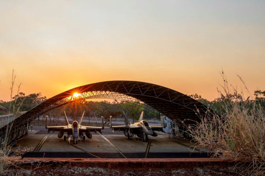 El sol se pone detrás de dos F/A-18F Super Hornets de la Real Fuerza Aérea Australiana en la zona de carga de artillería de la base Tindal de la RAAF, en el Territorio del Norte, durante el ejercicio Talisman Sabre 2023. ©Defensa Australia