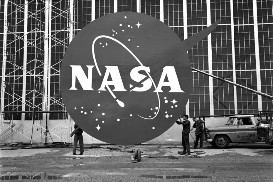 Trabajadores instalan el logotipo de la "albóndiga" de la NASA en la fachada del Edificio de Investigación de Vuelo, o hangar, en el Centro de Investigación Lewis (ahora NASA Glenn) en 1962. Crédito: ©NASA