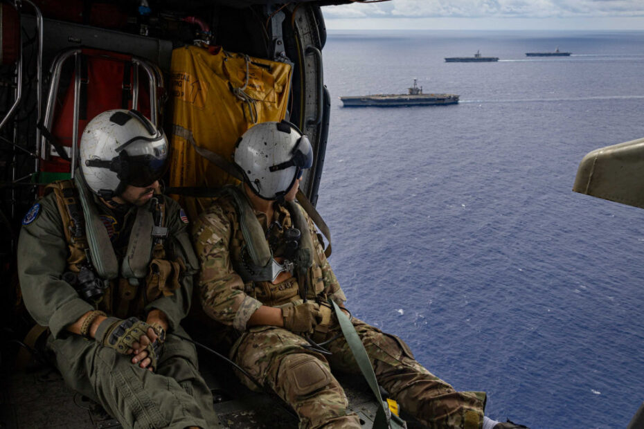 El tripulante aeronaval (helicóptero) de 3ª clase Jordan Marciano, natural de Brasil, a la izquierda, y el tripulante aeronaval (helicóptero) de 3ª clase Isaiah Martinez, natural de La Morada, California, a la derecha, ambos asignados a los «Guerreros Orgullosos» del Escuadrón de Ataque Marítimo de Helicópteros (HSM) 72, sobrevuelan los portaaviones de clase Nimitz USS Harry S. Truman (CVN 75), USS Dwight D. Eisenhower (CVN 69) y el portaaviones de clase Ford USS Gerald R. Ford (CVN 78) durante una transferencia de artillería, el 24 de agosto. Los portaaviones de clase Nimitz USS Harry S. Truman (CVN 75), USS Dwight D. Eisenhower (CVN 69), y el portaaviones de clase Ford USS Gerald R. Ford (CVN 78) están en marcha en el Océano Atlántico para una transferencia de artillería entre los tres buques y el buque de carga seca de clase Lewis y Clark USNS William McLean (T-AKE 12). (Foto de la Marina de los EE.UU. por el Especialista en Comunicación de Masas de 2ª Clase Matthew Nass)