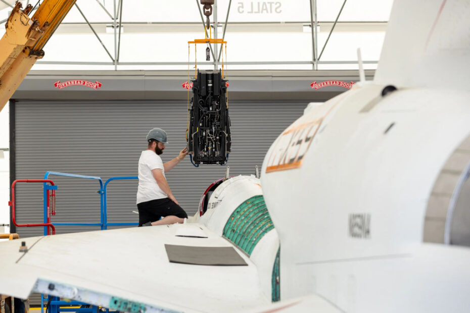 El técnico de soporte vital de la NASA Matthew Sechler ayuda a instalar un asiento eyectable en el avión X-59, en las instalaciones de Lockheed Martin Skunk Works, en Palmdale, California. La culminación de instalación del asiento marca un hito en la integración de la aeronave mientras se prepara para las pruebas en tierra firme. Crédito: Lockheed Martin