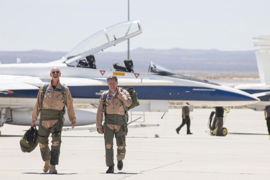 Los pilotos de la NASA Nils Larson y Wayne Ringelberg se dirigen a un informe de la misión después de volar un F/A-18 de la NASA a Mach 1,38 para crear estampidos sónicos como parte de la serie de vuelos Sonic Booms in Atmospheric Turbulence en el Armstrong Flight Research Center de la NASA en California, para estudiar las firmas de estampidos sónicos con y sin el elemento de turbulencia atmosférica. ©NASA/Lauren Hughes