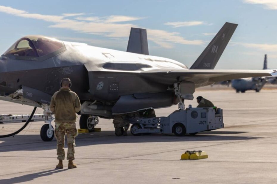 Miembros de la tripulación de carga de armas cargan municiones en un F-35A Lightning II mientras los motores de la aeronave permanecen en marcha durante las pruebas de giro de combate integrado en la Base Aérea de Nellis, Nevada. Este procedimiento, el primero de su clase para el F-35, reduce el tiempo de regeneración de la aeronave al permitir el reabastecimiento «en caliente» y la carga de armas simultáneamente, disminuyendo la vulnerabilidad de la aeronave en tierra de tres horas a menos de 25 minutos. (Foto de la Guardia Nacional Aérea de EE.UU. por el sargento mayor Charles Givens).