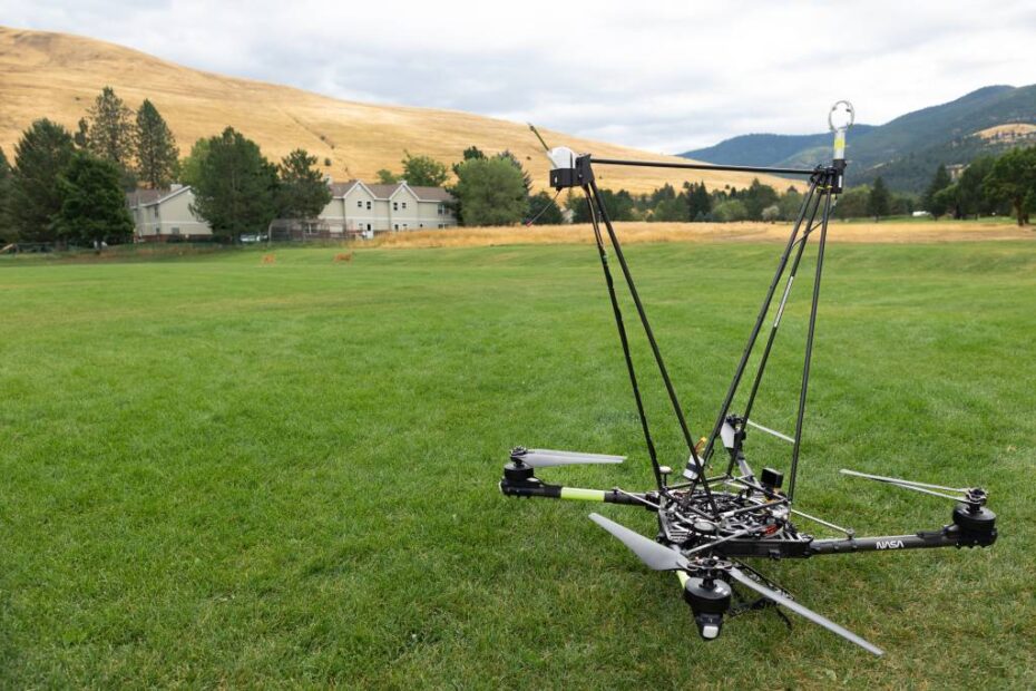 El cuadricóptero Alta X de la NASA se encuentra en un campo de Missoula, equipado con una estructura especial para transportar en el aire una radiosonda (sensor de la izquierda) y un anemómetro (sensor de la derecha). Esta estructura fue diseñada en el Centro de Investigación Langley de la NASA para garantizar que los sensores estén lo suficientemente lejos de los rotores para evitar interferencias con los datos recogidos, pero sin comprometer la estabilidad del dron. ©NASA/Milan Loiacono