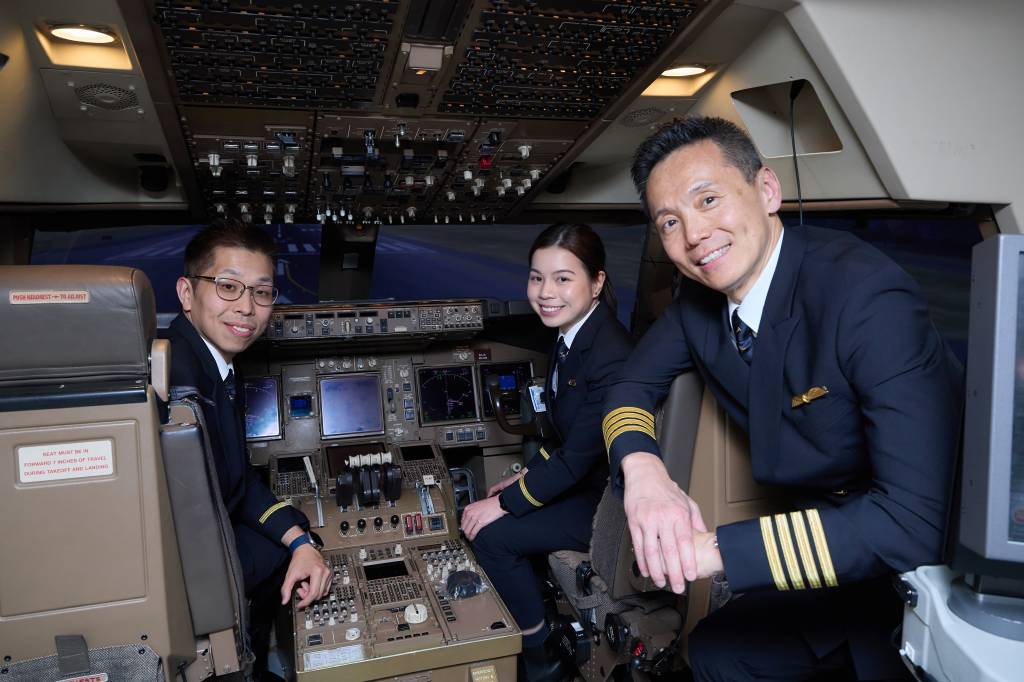 Los cadetes graduados Tony Yung y Kellie Chiu y el Director de Formación (Desarrollo de Pilotos) de Cathay Pacific, el capitán Joe Fung, fotografiados en un simulador de vuelo. ©Cathay Pacific