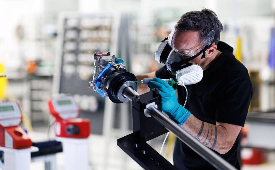 Un técnico de Collins Aerospace aplica sellador a una pieza del actuador del sistema inversor del empuje eléctrico (elecTRAS) del A350 en la nueva línea de producción de Colomiers, Francia. ©RTX/Collins Aerospace
