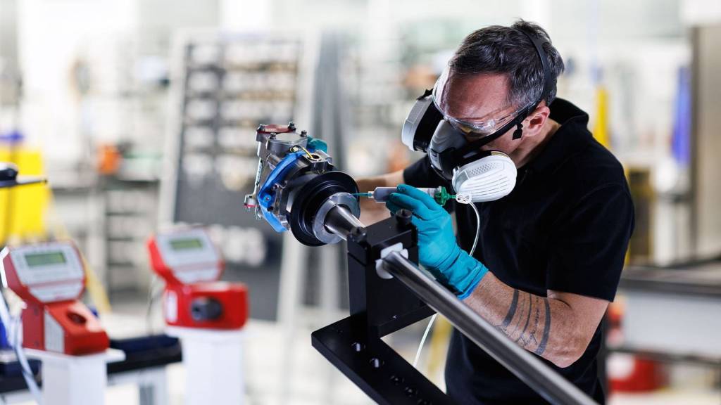 Un técnico de Collins Aerospace aplica sellador a una pieza del actuador del sistema inversor del empuje eléctrico (elecTRAS) del A350 en la nueva línea de producción de Colomiers, Francia. ©RTX/Collins Aerospace