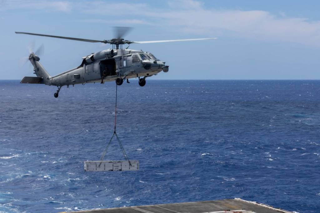 Un helicóptero MH-60S Sea Hawk, adscrito al escuadrón «Dragonslayers» del Escuadrón de Combate Marítimo de Helicópteros (HSC) 11, transporta municiones desde la cubierta de vuelo del portaaviones clase Nimitz USS Harry S. Truman (CVN 75) al buque de suministro clase Lewis and Clark USNS Robert E. Peary (T-AKE 5) durante una descarga de municiones. El Truman se encuentra actualmente navegando por el océano Atlántico. (Foto del marinero especialista en comunicación masiva Michael Gómez)