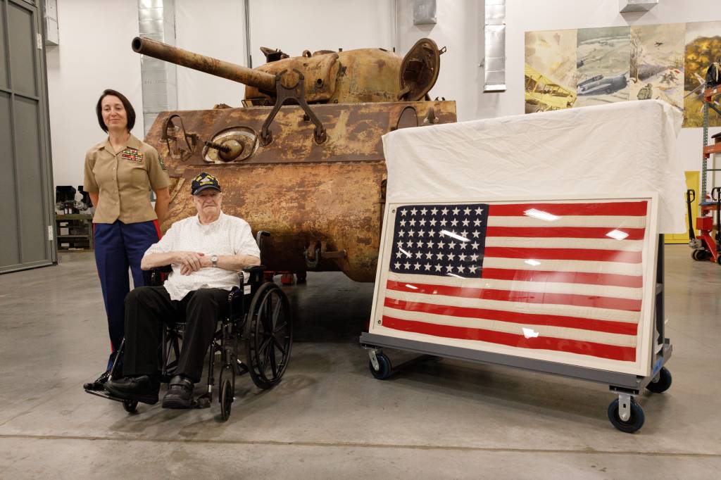 El cabo Leighton Willhite, veterano del Cuerpo de Marines de EE.UU. que participó en la batalla de Iwo Jima, a la derecha, posa para una foto delante del tanque Sherman de la Segunda Guerra Mundial con la maestra artillera Gt. Lisa Marshall, consejera profesional superior, en las instalaciones de apoyo al museo de Dumfries, Virginia. ©U.S. Marine Corps