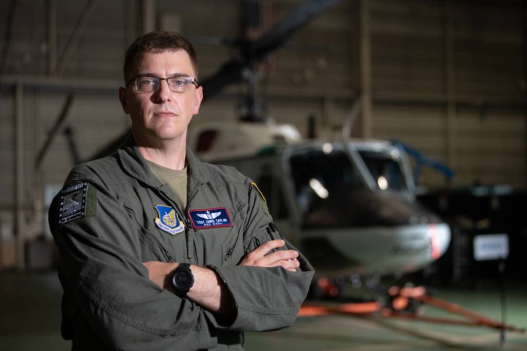 El sargento técnico Christopher Taylor, de la Fuerza Aérea de EE.UU., aviador de misiones especiales del 459.º Escuadrón de Transporte Aéreo, posa delante de un UH-1N Huey en la base aérea de Yokota, Japón, el 5 de septiembre de 2025. El UH-1N llegó por primera vez a Yokota en 1980 y, durante más de 45 años, la aeronave prestó apoyo a una amplia gama de misiones en toda la región, incluidas evacuaciones aeromédicas y el transporte de altos funcionarios del Gobierno. También desempeñó un papel fundamental en la Operación Tomodachi tras el gran terremoto del este de Japón de 2011, realizando vuelos de reconocimiento y cartografía de radiación de bajo nivel tras el desastre de la central nuclear de Fukushima Daiichi. (Fotografía de la Fuerza Aérea de EE.UU. realizada por la sargento primero Natalie Doan)