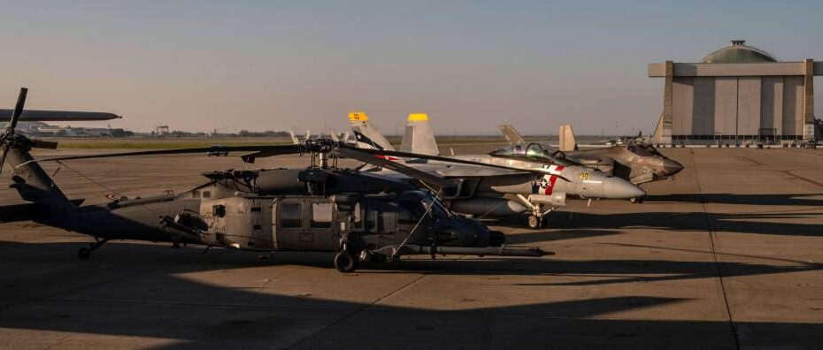 Un helicóptero HH-60W Jolly Green II de la Fuerza Aérea de los Estados Unidos, perteneciente al 129.º Ala de Rescate de la Guardia Aérea Nacional de California, con base en la Base Aérea Nacional de Moffett, se encuentra en la pista, el 4 de febrero de 2026, mientras la base acoge a los aviones que sobrevuelan la Super Bowl LX, entre los que se encuentran un F/A-18F Super Hornet de la Armada de los Estados Unidos, perteneciente al Escuadrón de Cazas de Ataque 2 (VFA-2), y un F-35C Lightning II de la Armada, perteneciente al Escuadrón de Cazas de Ataque 97 (VFA-97). Foto de la sargento técnico Crystal Housman.