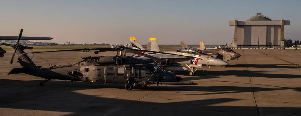 Un helicóptero HH-60W Jolly Green II de la Fuerza Aérea de los Estados Unidos, perteneciente al 129.º Ala de Rescate de la Guardia Aérea Nacional de California, con base en la Base Aérea Nacional de Moffett, se encuentra en la pista, el 4 de febrero de 2026, mientras la base acoge a los aviones que sobrevuelan la Super Bowl LX, entre los que se encuentran un F/A-18F Super Hornet de la Armada de los Estados Unidos, perteneciente al Escuadrón de Cazas de Ataque 2 (VFA-2), y un F-35C Lightning II de la Armada, perteneciente al Escuadrón de Cazas de Ataque 97 (VFA-97). Foto de la sargento técnico Crystal Housman.
