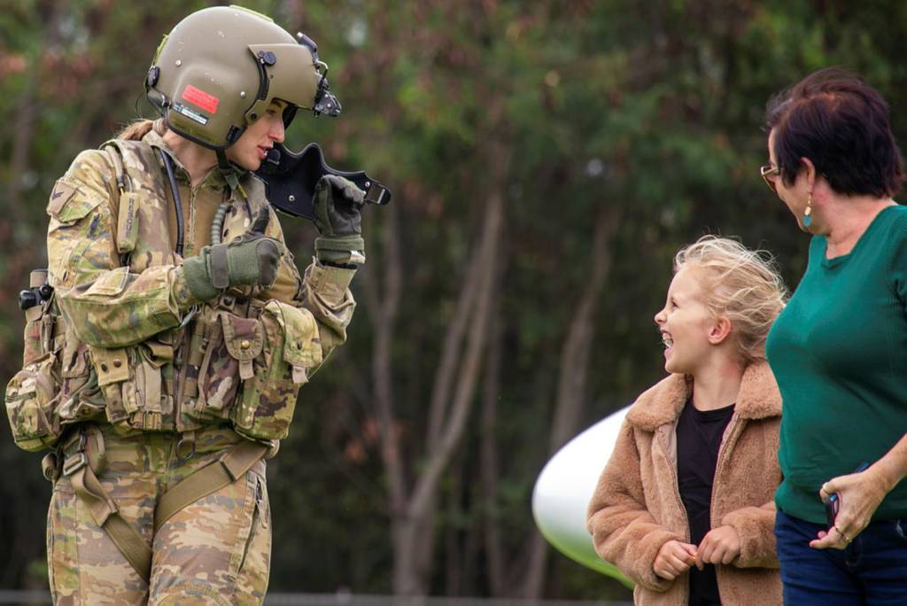 La soldado del Ejército Australiano, la cabo Charlotte Mears, del 5.º Regimiento de Aviación, le da el visto bueno a una niña tras un vuelo en un helicóptero AW139 alquilado por el Ejército durante la Operación Care Bear en Townsville, Queensland. ©Departamento de Defensa de Australia
