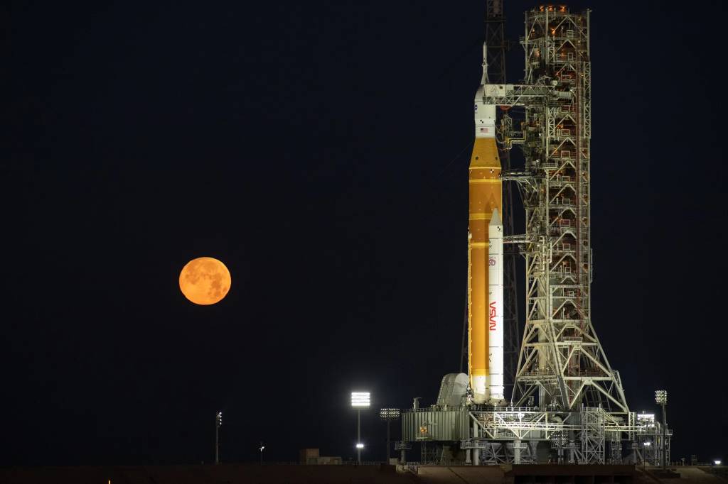 La Luna se eleva detrás del cohete Sistema de Lanzamiento Espacial y la nave espacial Orion de la misión Artemis II de la NASA, situados sobre una plataforma móvil de lanzamiento en el Complejo de Lanzamiento 39B del Centro Espacial Kennedy de la NASA en Florida, el domingo 1 de febrero de 2026. El vuelo de prueba Artemis II llevará al comandante Reid Wiseman, al piloto Victor Glover y a la especialista de misión Christina Koch, de la NASA, y al especialista de misión Jeremy Hansen, de la CSA (Agencia Espacial Canadiense), alrededor de la Luna y de vuelta a la Tierra. NASA/Ben Smegelsky