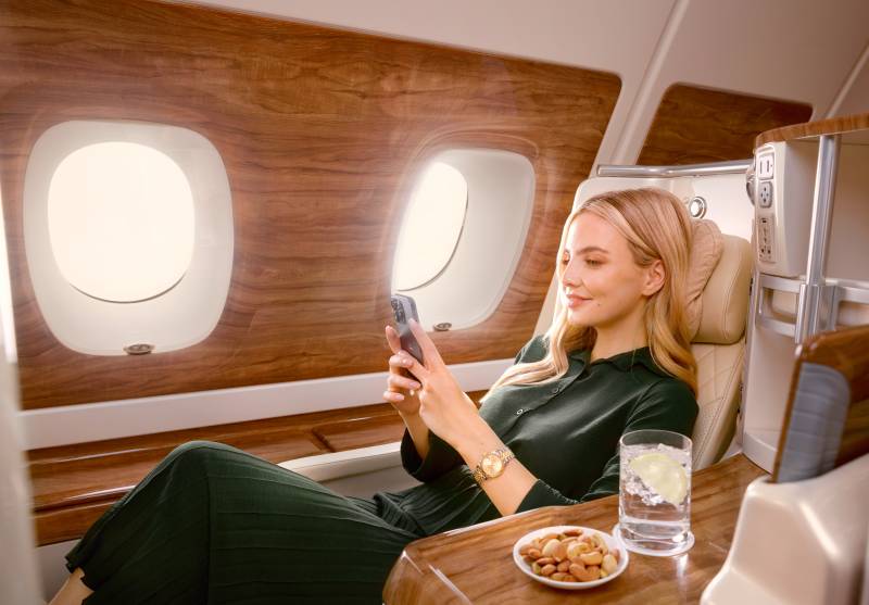 Una pasajera ve contenido en streaming en su teléfono móvil a bordo de un A380 de Emirates utilizando el Wi-Fi de Starlink ©Emirates