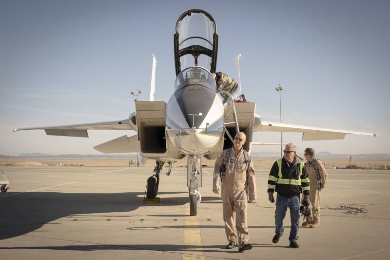 El piloto de la NASA Nils Larson, a la izquierda, camina junto al jefe de tripulación Walt Kondracki, a la derecha, junto a un avión F-15 el martes 13 de enero de 2026, en el Centro de Investigación de Vuelo Armstrong de la NASA, en Edwards, California. Al fondo, el mecánico de la NASA Tim Logan fija la cabina del F-15, y el ingeniero de pruebas de vuelo A.J. Jaffe se encuentra de pie a la derecha. ©NASA/Christopher LC Clark