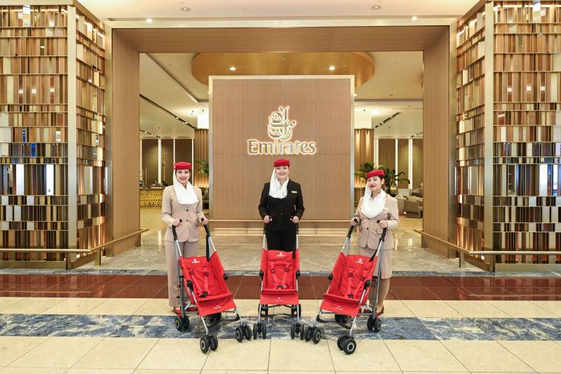 En la imagen se ve al equipo de Emirates junto a unos cochecitos en el Aeropuerto Internacional de Dubái (DXB), mostrando los cochecitos gratuitos que se ofrecen a las familias. Más de 400 de estos cochecitos fueron reacondicionados y limpiados profesionalmente antes de ser donados a organizaciones locales. ©Emirates