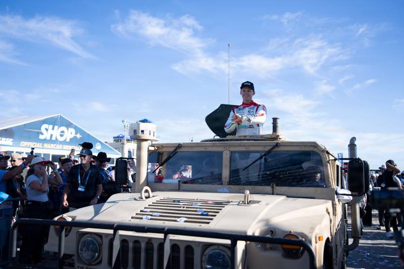 El piloto de NASCAR Corey Heim, en el centro, posa para una foto en un vehículo multipropósito con ruedas de alta movilidad tras ganar la carrera de la NASCAR Cup Series durante el fin de semana de NASCAR en San Diego, celebrado en la Base Naval de Coronado, el 21 de junio de 2026. Crédito: Contramaestre de tercera clase de la Marina James D. Peer