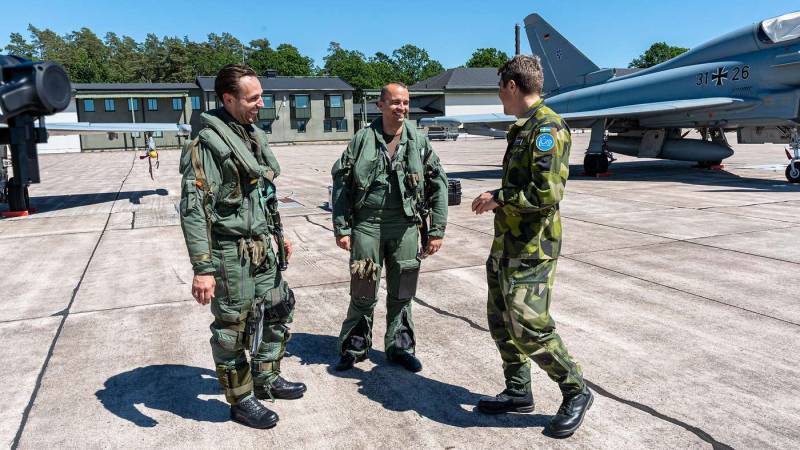 El comandante de escuadrón sueco conversa con un piloto alemán y otro sueco después de un vuelo en un Eurofighter. ©Bundeswehr/Sebastian Thomas
