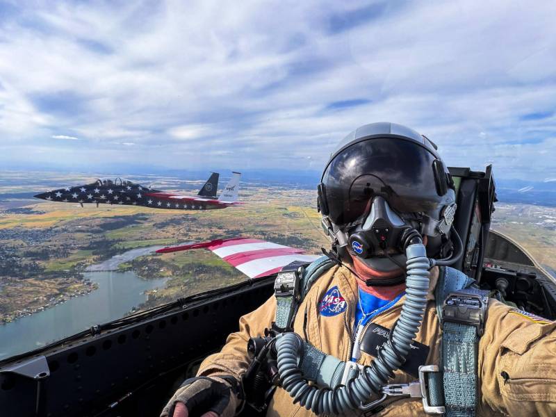 El fotógrafo de la NASA Jim Ross se toma una selfie desde el asiento trasero de un F/A-18 de la NASA durante un vuelo a través del país desde Spokane, Washington, hasta Washington, D.C., el jueves 2 de julio de 2026. A través de la ventanilla se ve el F-15 de la agencia, que vuela junto a la aeronave. Ambas aeronaves, del Centro de Investigación de Vuelo Armstrong de la NASA en Edwards, California, participaron en el sobrevuelo «Freedom 250» junto con otras aeronaves de la NASA y del ejército el sábado 4 de julio de 2026. ©NASA/Jim Ross