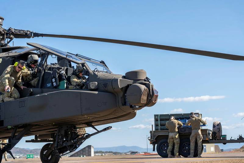 Soldados del Ejército australiano pertenecientes al 1.er Regimiento de Aviación realizan tareas de rearmado y reabastecimiento de combustible en un helicóptero AH-64E Apache australiano en la Base de la RAAF de Townsville durante el ejercicio «Possum Guns». ©Departamento de Defensa de Australia