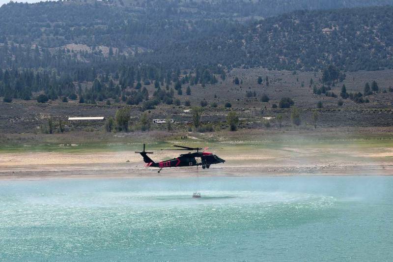 Un helicóptero UH-60 Black Hawk de la Guardia Nacional del Ejército de Utah recoge agua en un balde del embalse de Joe's Valley mientras presta apoyo a las operaciones aéreas de extinción de incendios en el incendio de Black Canyon, en el condado de Sanpete, Utah, el 5 de agosto de 2026. Las tripulaciones de aviación están apoyando a las agencias locales y gubernamentales mientras los incendios forestales siguen afectando a comunidades de todo el estado. Crédito: Suboficial 4 del Ejército de EE. UU. Chris Aylstock ©US Army