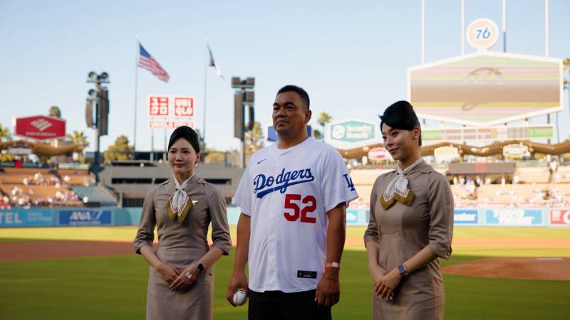 El pionero del béisbol taiwanés, Chin-Feng Chen, posa en el UNIQLO Field del Dodger Stadium junto a la tripulación de cabina de STARLUX Airlines antes de lanzar el primer lanzamiento ceremonial de la «Noche de STARLUX», el 1 de agosto de 2026. ©STARLUX Airlines