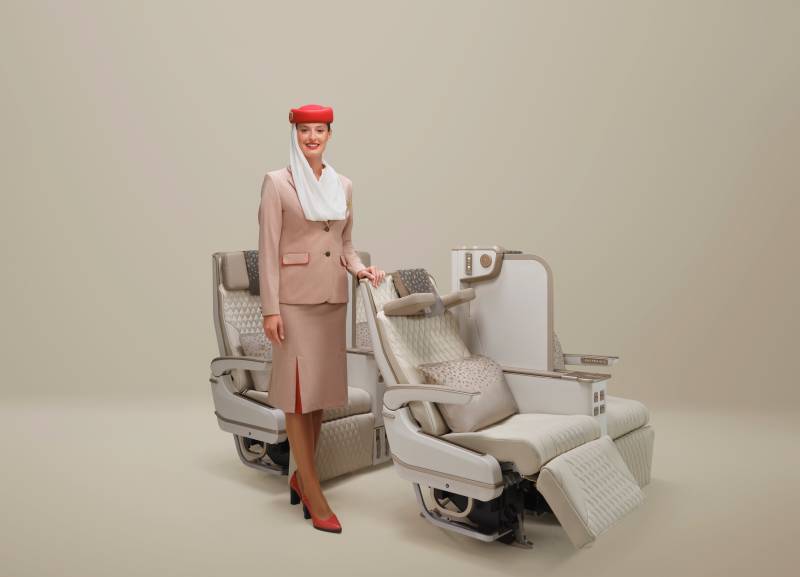 Esta imagen muestra el nuevo asiento de clase Premium Economy de Emirates, con accionamiento eléctrico, junto a la tripulación de cabina de Emirates. El nuevo asiento cuenta con una pantalla de privacidad ajustable en toda su altura, un reposacabezas U-Dream y un reposapiés de cuero, lo que ofrece a los clientes mayor comodidad y control sobre su espacio personal. ©Emirates