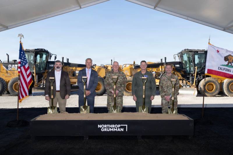 De izquierda a derecha: William Bailey, quien desempeña las funciones de subsecretario de la Fuerza Aérea para Adquisiciones, Tecnología y Logística; Chris Adams, vicepresidente de sector de Northrop Grumman y gerente general del programa B-21; el general Dale White, director de Sistemas de Armas Críticos del Departamento de Guerra; el general de división Peter Bonetti, director de Planes Estratégicos, Programas y Requisitos del Comando de Ataque Global de la Fuerza Aérea; y el coronel Nicholas Jordan, director del Programa del Sistema B-21 de la Fuerza Aérea de EE. UU., posan para una foto frente a una obra en Palmdale, California, el 29 de septiembre de 2026. El Departamento de la Fuerza Aérea y Northrop Grumman iniciaron la construcción de la nueva línea de ensamblaje final en la Planta 42 de la Fuerza Aérea, lo que marca un paso significativo hacia la expansión de la capacidad de producción del B-21 Raider y la entrega más rápida de capacidad de combate a la Fuerza Conjunta. (Foto cortesía de Northrop Grumman)